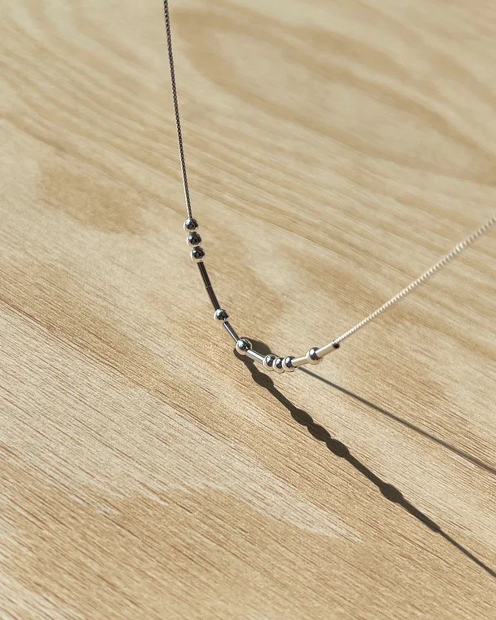 Detaljbild på pärlorna i morsekodshalsband i silver
