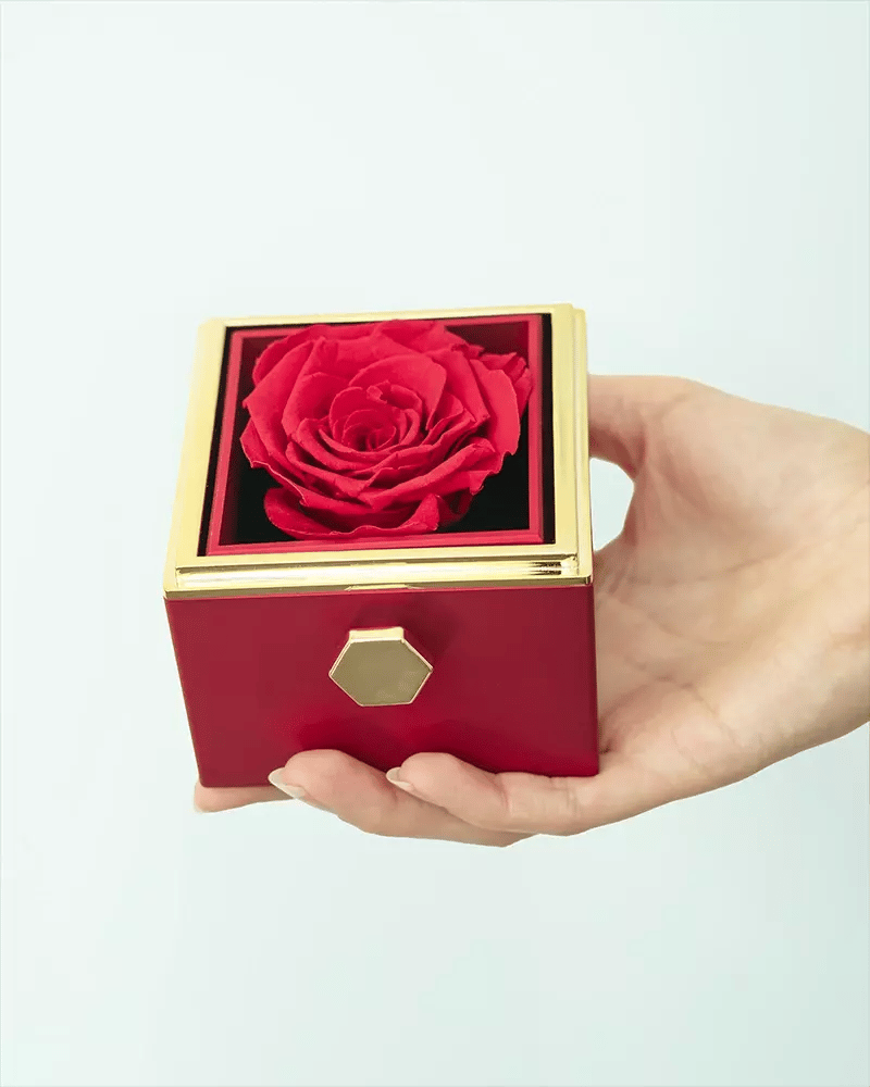 Hand som vrider på rosen och visar namnhalsbandet i rosboxen